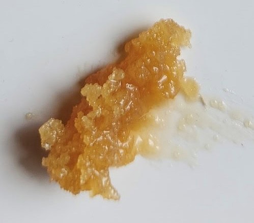 A sample of honey shown on a cutting board.
